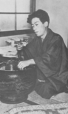 Imagem: Takiji Kobayashi com bebida na mão.