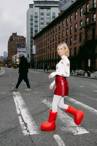 imagem: moça andando com bota do astroboy na rua.