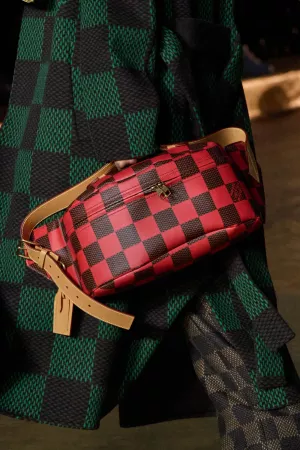 imagem: foto mostrando casaco xadrez preto e verde escuro e bolsa xadrez preto e vermelho.