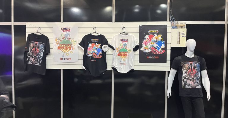 imagem: camisetas e pôsteres de Sonic e Persona 5 no estande de vendas da Sega na Brasil Game Show 2023