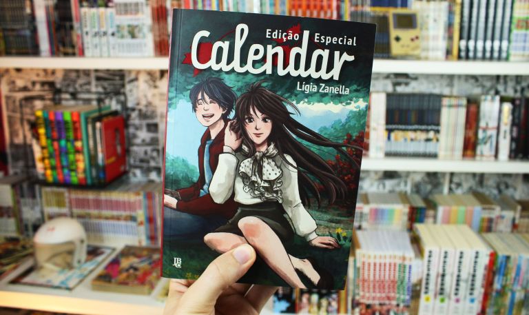 imagem: mão segurando o mangá Calendar, mostrando a capa